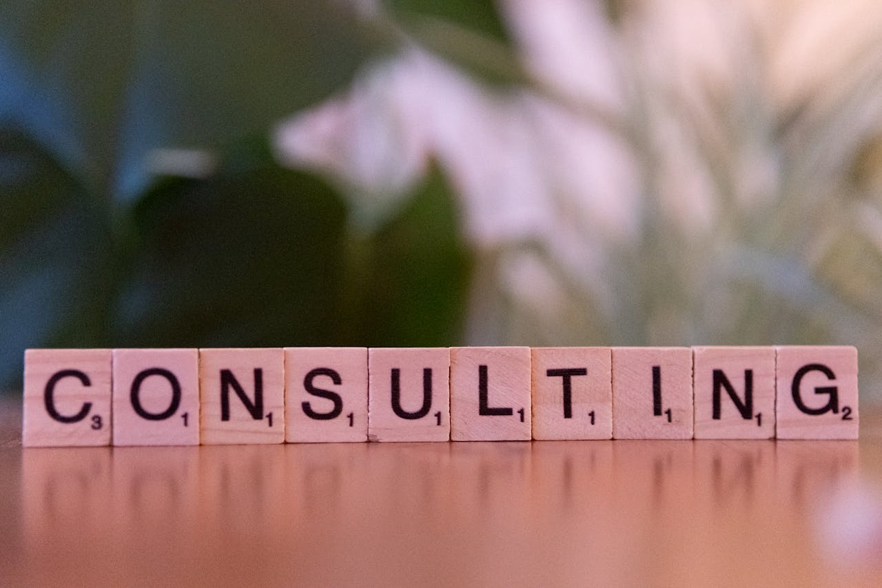 about-bg Wooden letter tiles spelling Consulting with a blurred background. Ideal for business concepts.