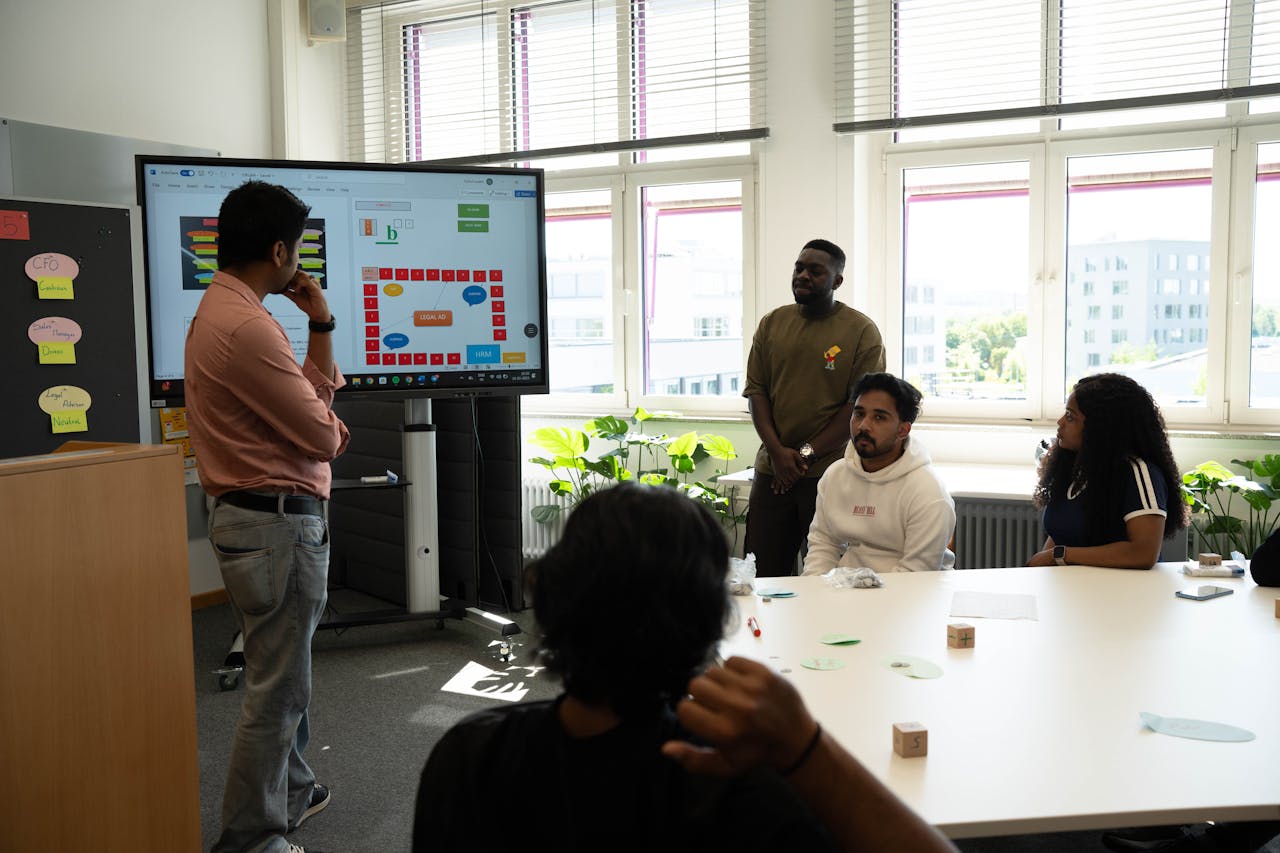 services-06 Group of diverse young professionals collaborating with a presentation in a bright office.